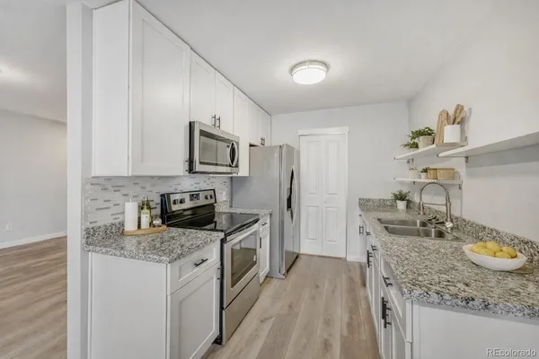 a kitchen with granite countertop stainless steel appliances a stove sink and microwave