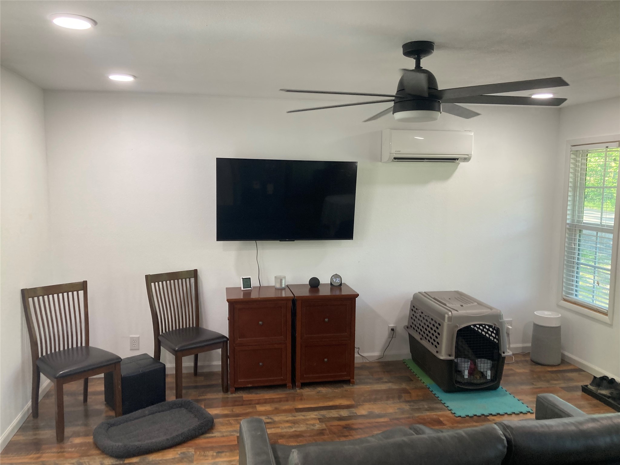 142 Walnut Ridge Livingston, TX 77351 - Photo 2 of 36 Cozy living room with modern ceiling fan, large wall-mounted TV, and ample natural light from the window. Perfect for relaxation and entertainment.