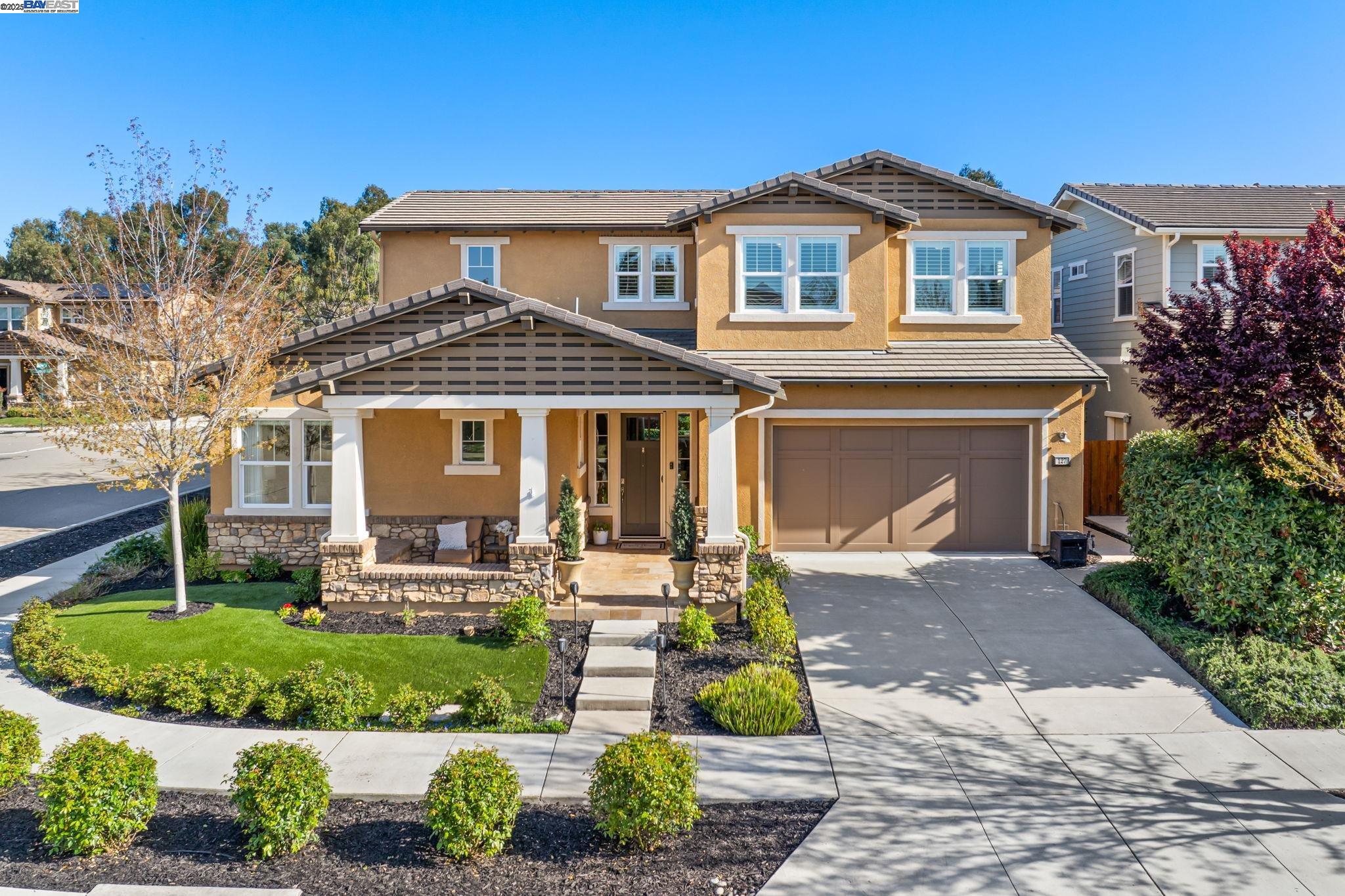 a front view of a house with a yard and potted plants