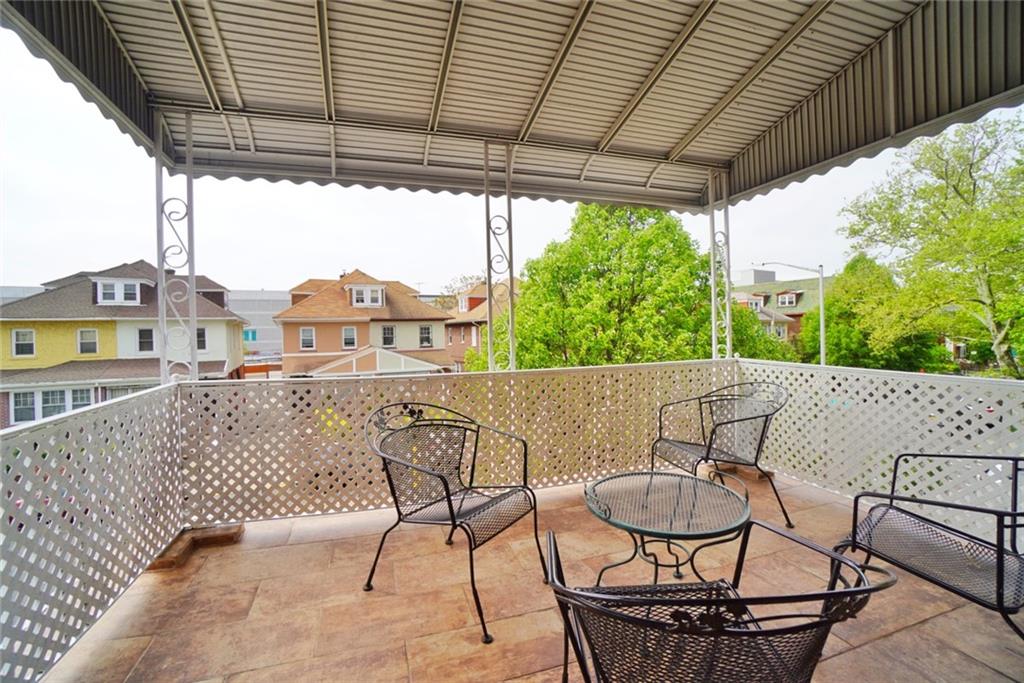 157 Sullivan Place Brooklyn, NY 11225 - Photo 11 of 28 a view of a patio with table and chairs with wooden floor and fence