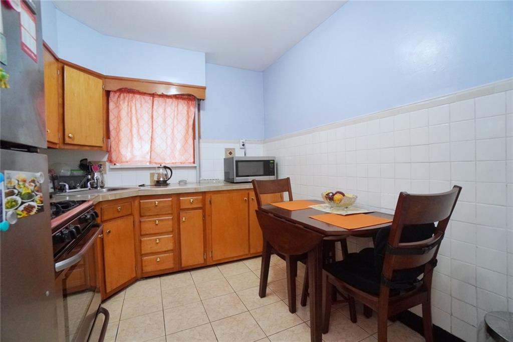 157 Sullivan Place Brooklyn, NY 11225 - Photo 17 of 28 a kitchen with stainless steel appliances granite countertop a sink a stove a dining table and chairs
