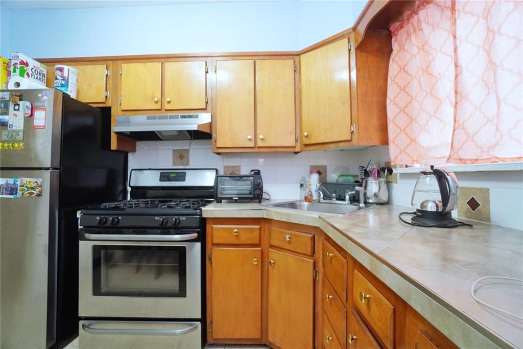 157 Sullivan Place Brooklyn, NY 11225 - Photo 18 of 28 a kitchen with stainless steel appliances granite countertop a stove a sink and a microwave