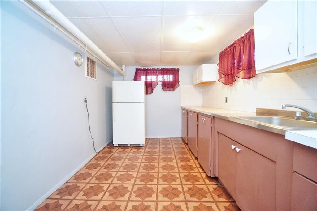 157 Sullivan Place Brooklyn, NY 11225 - Photo 25 of 28 a kitchen with a sink a refrigerator and cabinets