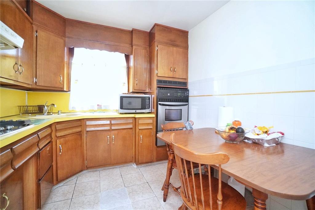 157 Sullivan Place Brooklyn, NY 11225 - Photo 8 of 28 a kitchen with stainless steel appliances granite countertop a sink dishwasher stove refrigerator and cabinets