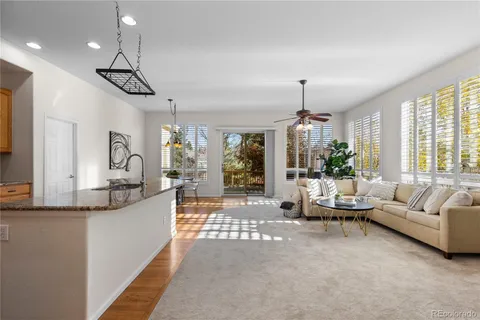 a living room with furniture a chandelier and a dining table