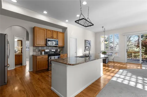 a living room with stainless steel appliances kitchen island granite countertop furniture and a kitchen view