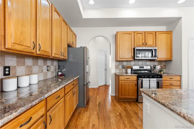 a kitchen with stainless steel appliances granite countertop a stove a sink and a microwave