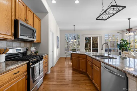 a kitchen with stainless steel appliances a sink dishwasher stove microwave and cabinets with wooden floor