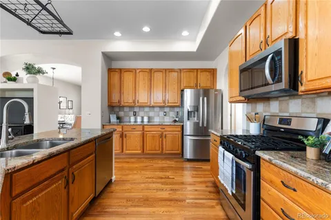 a kitchen with stainless steel appliances granite countertop a stove a sink dishwasher and a refrigerator