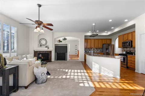 a living room with furniture a fireplace and kitchen view