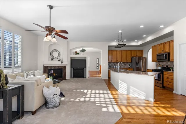 a living room with furniture a fireplace and kitchen view