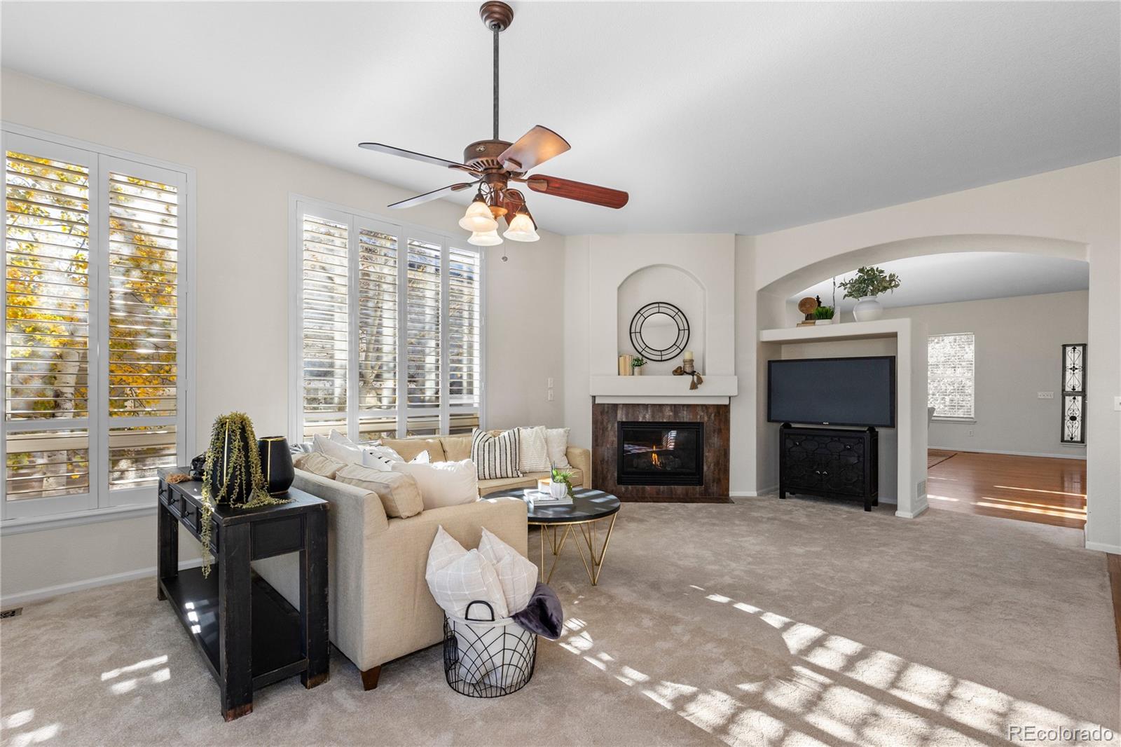 8166 Wetherill Circle Castle Pines, CO 80108 - Photo 19 of 49 a living room with furniture a window and a fireplace