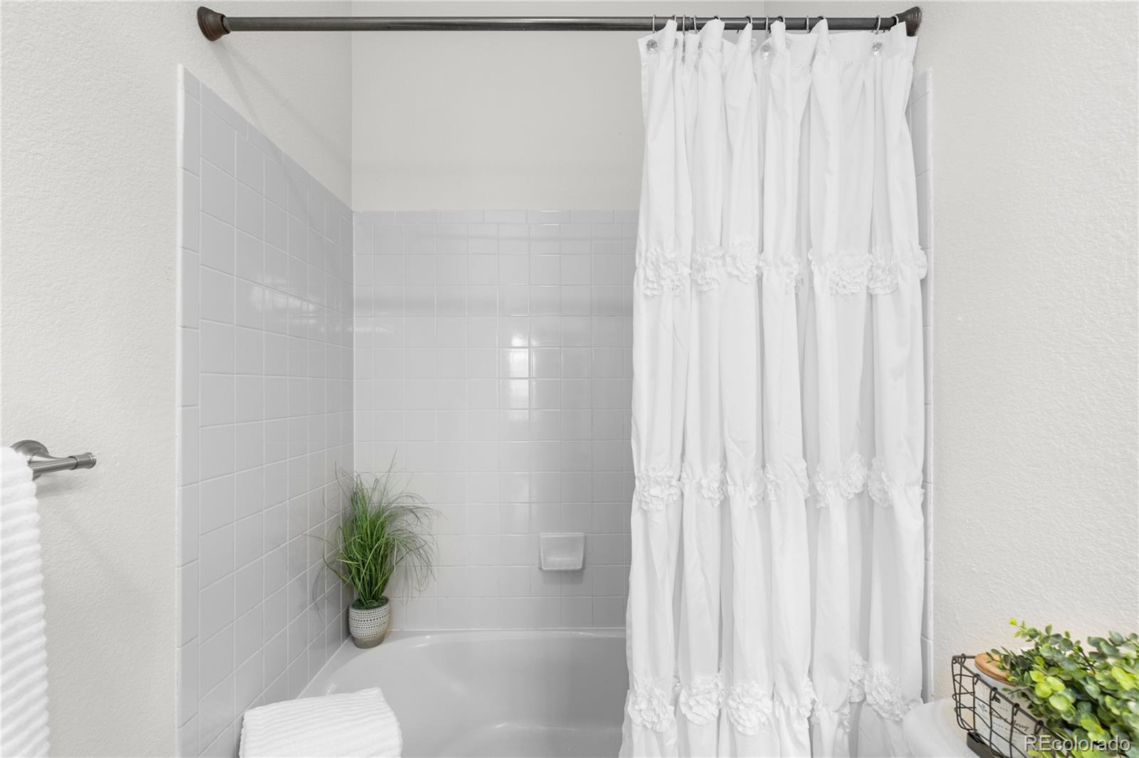 8166 Wetherill Circle Castle Pines, CO 80108 - Photo 25 of 49 a bathroom with a shower curtain and a window