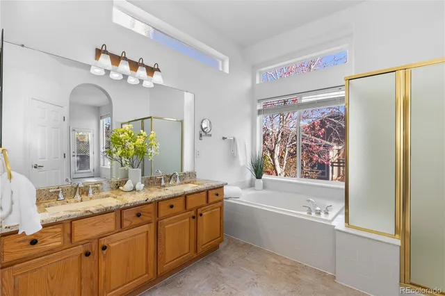 a bathroom with a double vanity sink mirror and a bathtub