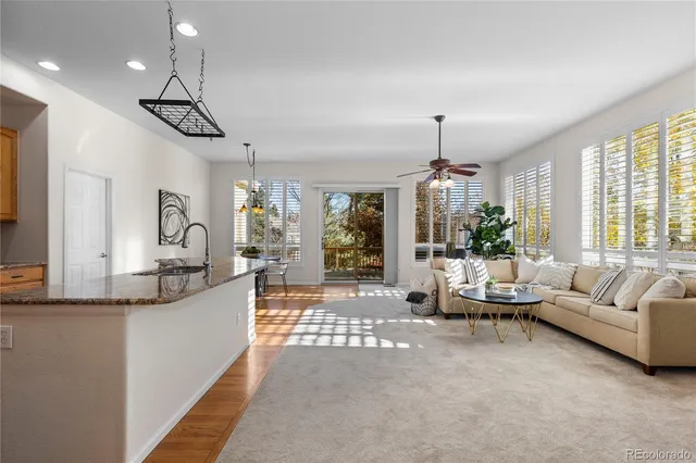 a living room with furniture a chandelier and a dining table