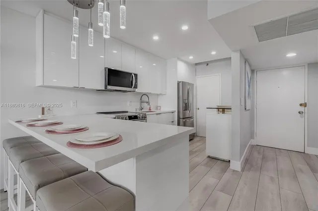 a kitchen with a sink a refrigerator and white cabinets