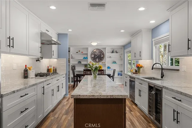 a large kitchen with stainless steel appliances granite countertop a lot of counter space and wooden cabinets