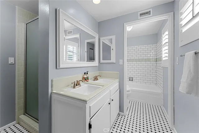 a bathroom with a sink a toilet a shower and a mirror