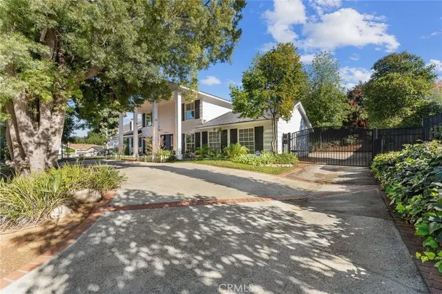 a front view of a house with a yard and trees