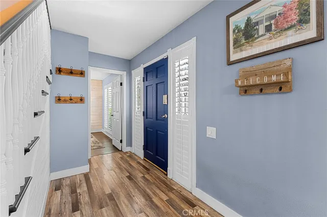 a view of a hallway with wooden floor and closet