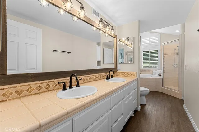 a bathroom with a sink double vanity granite tub and shower