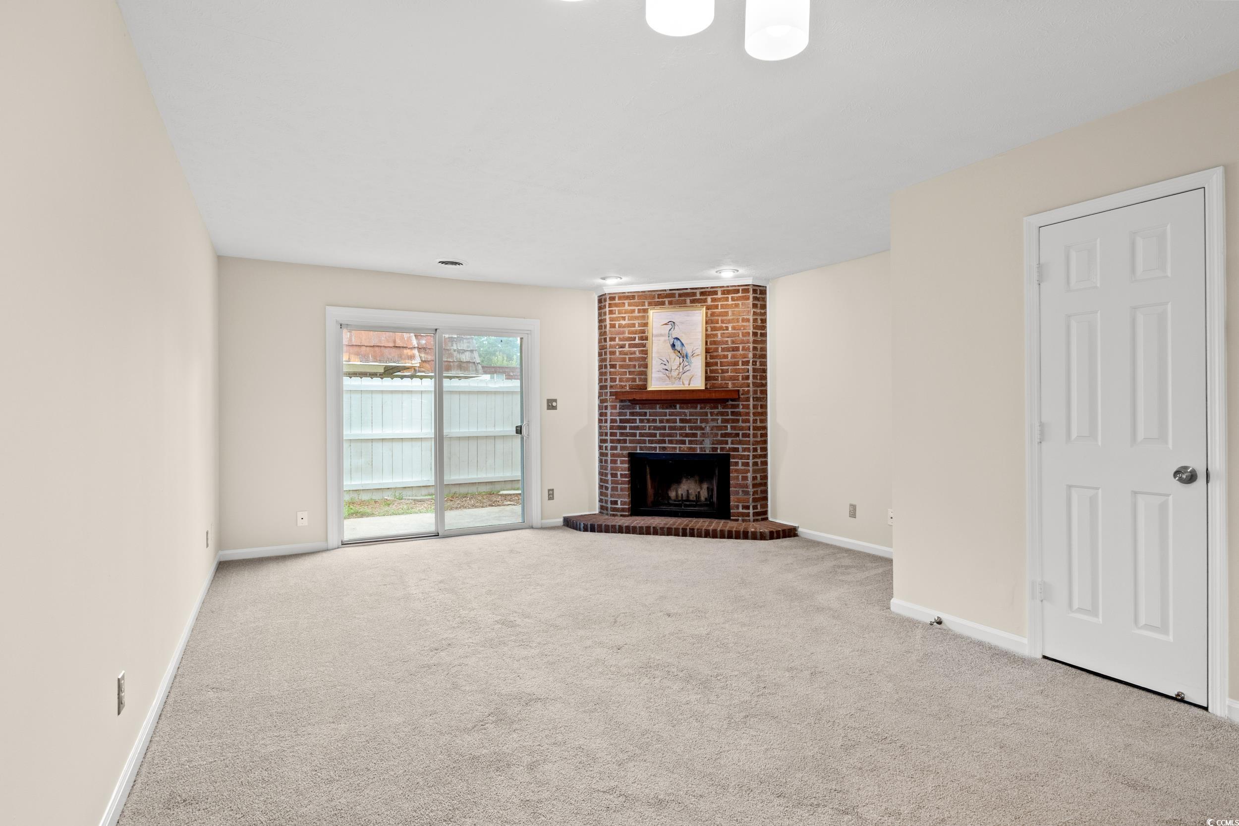 1025 Carolina Road, Unit S2 Conway, SC 29526 - Photo 10 of 27 Unfurnished living room with brick wall, a firepla