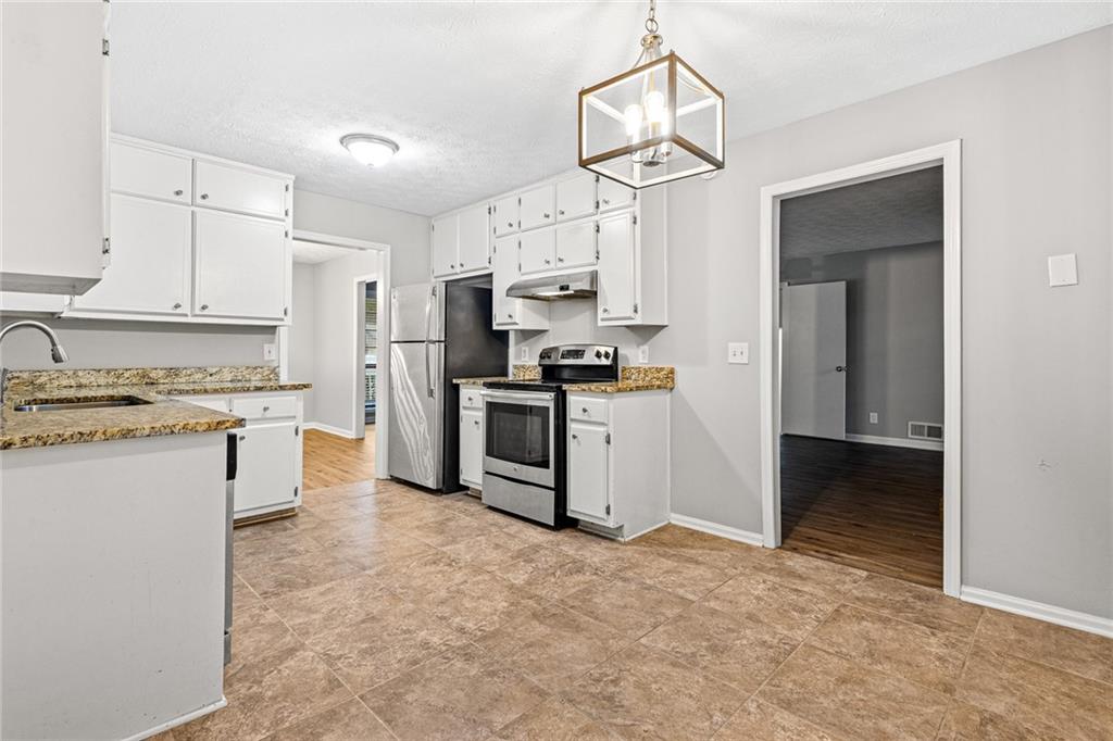 1735 Charmeth Road Lithonia, GA 30058 - Photo 11 of 27 a kitchen with a refrigerator sink and cabinets