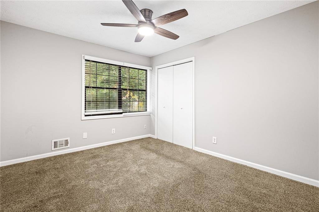 1735 Charmeth Road Lithonia, GA 30058 - Photo 12 of 27 an empty room with a window and a fan