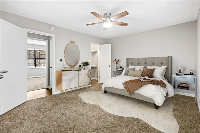 a spacious bedroom with a bed a table and painting on the wall
