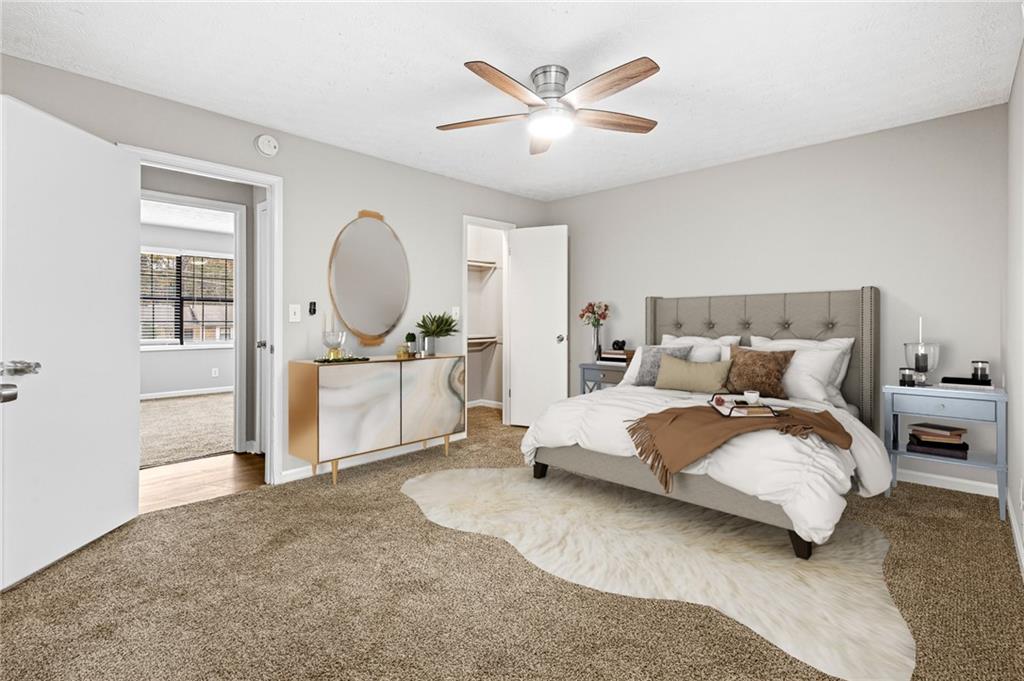 1735 Charmeth Road Lithonia, GA 30058 - Photo 17 of 27 a spacious bedroom with a bed a table and painting on the wall