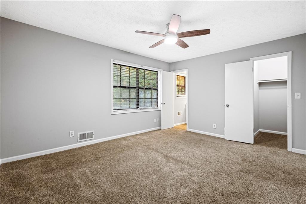 1735 Charmeth Road Lithonia, GA 30058 - Photo 20 of 27 an empty room with windows and ceiling fan
