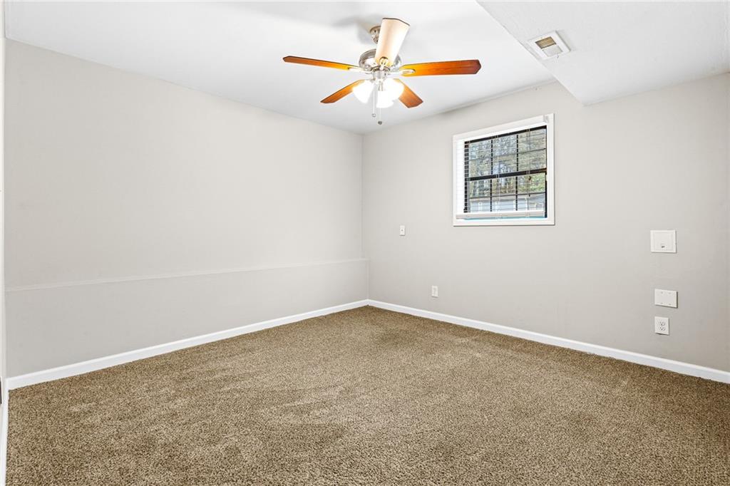 1735 Charmeth Road Lithonia, GA 30058 - Photo 23 of 27 an empty room with a window and a ceiling fan