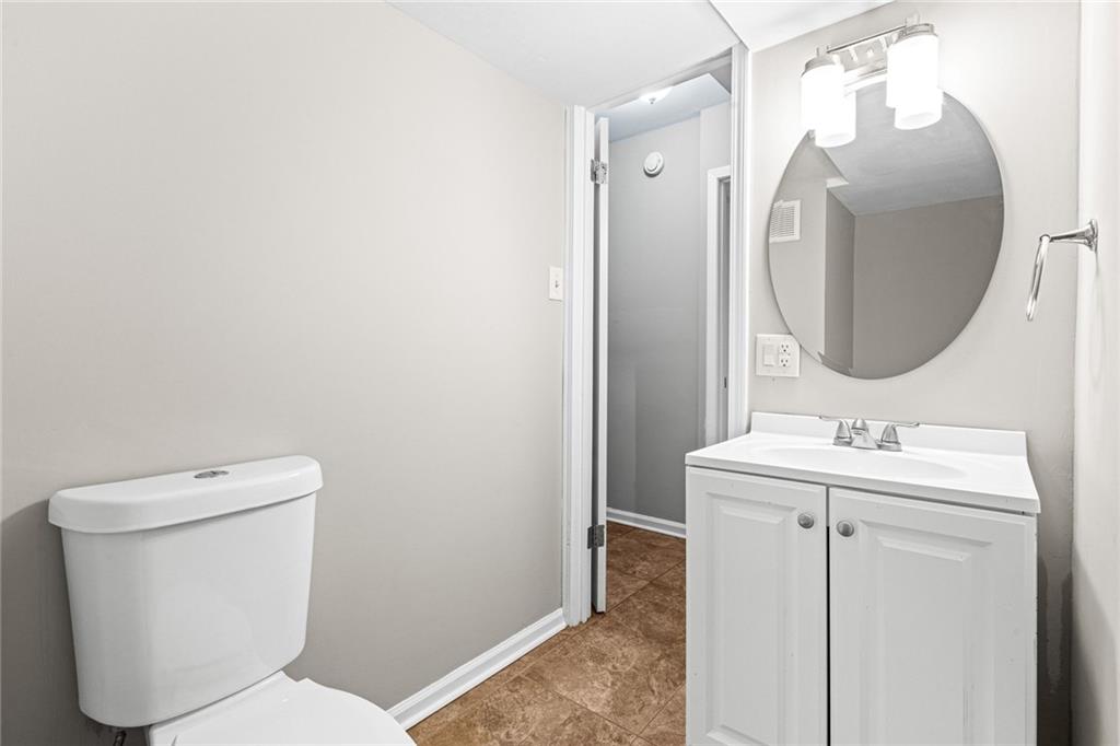 1735 Charmeth Road Lithonia, GA 30058 - Photo 24 of 27 a bathroom with a toilet a sink and mirror