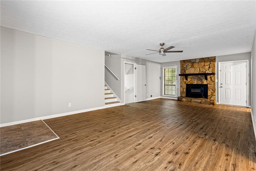 1735 Charmeth Road Lithonia, GA 30058 - Photo 4 of 27 an empty room with wooden floor fireplace and windows