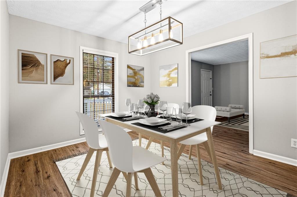 1735 Charmeth Road Lithonia, GA 30058 - Photo 5 of 27 a view of a dining room with furniture and wooden floor