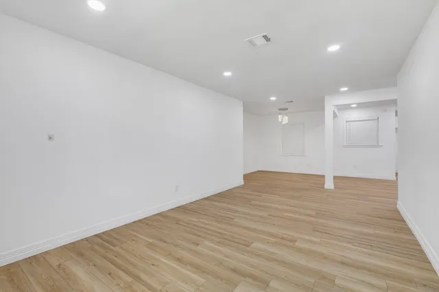 a view of empty room with wooden floor