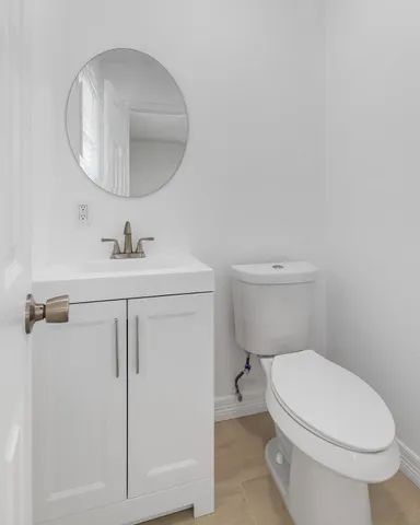 a bathroom with a toilet a sink and mirror