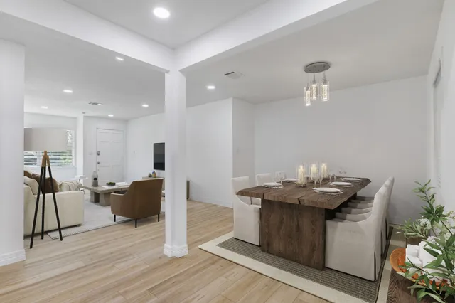 a dining hall with stainless steel appliances kitchen island granite countertop a table and chairs in it