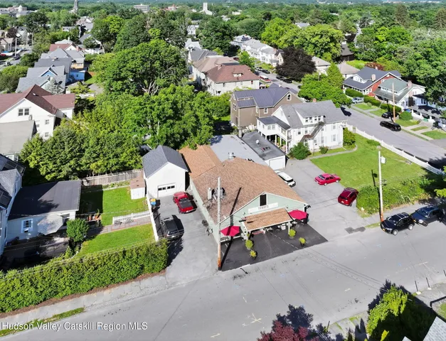 an aerial view of a city with lots of residential buildings and mountain view in back