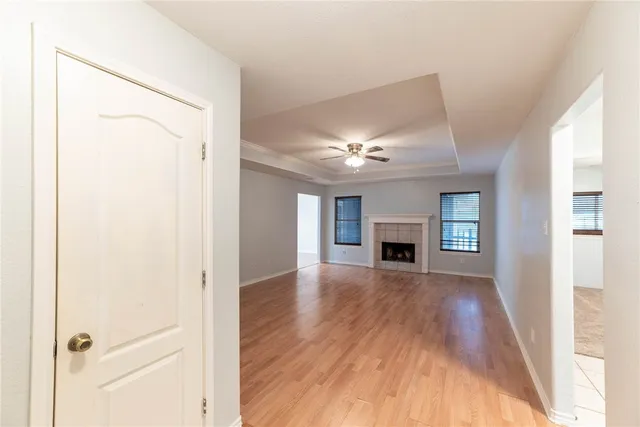 a view of a livingroom with wooden floor fireplace and window