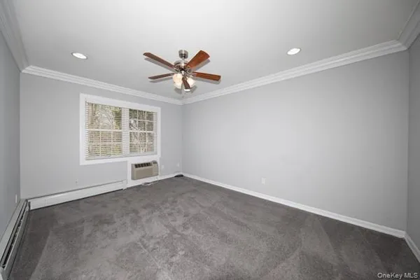 an empty room with windows and ceiling fan