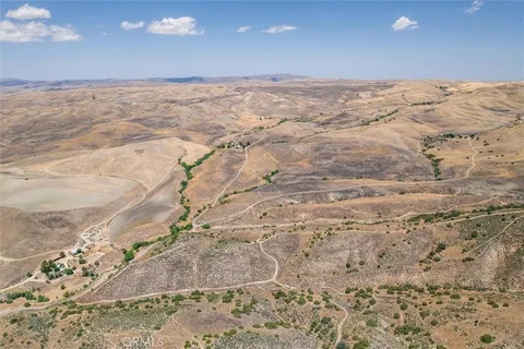 an aerial view of house with yard and mountain in the background