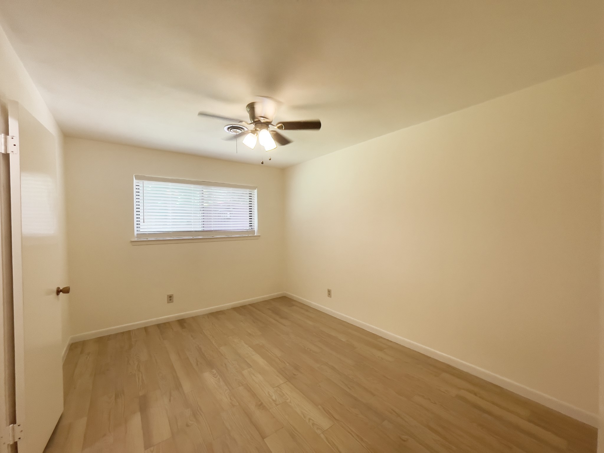 7710 Romney Road Houston, TX 77036 - Photo 15 of 31 an empty room with a window and a fan
