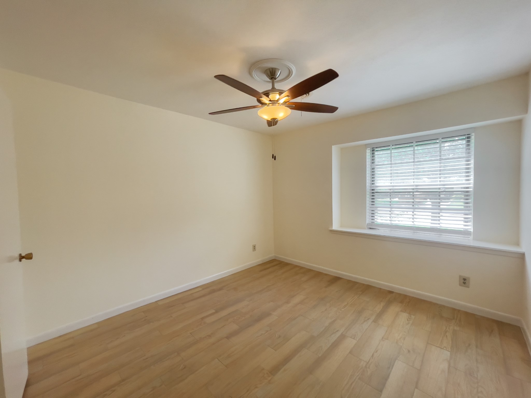 7710 Romney Road Houston, TX 77036 - Photo 21 of 31 an empty room with a window and a fan