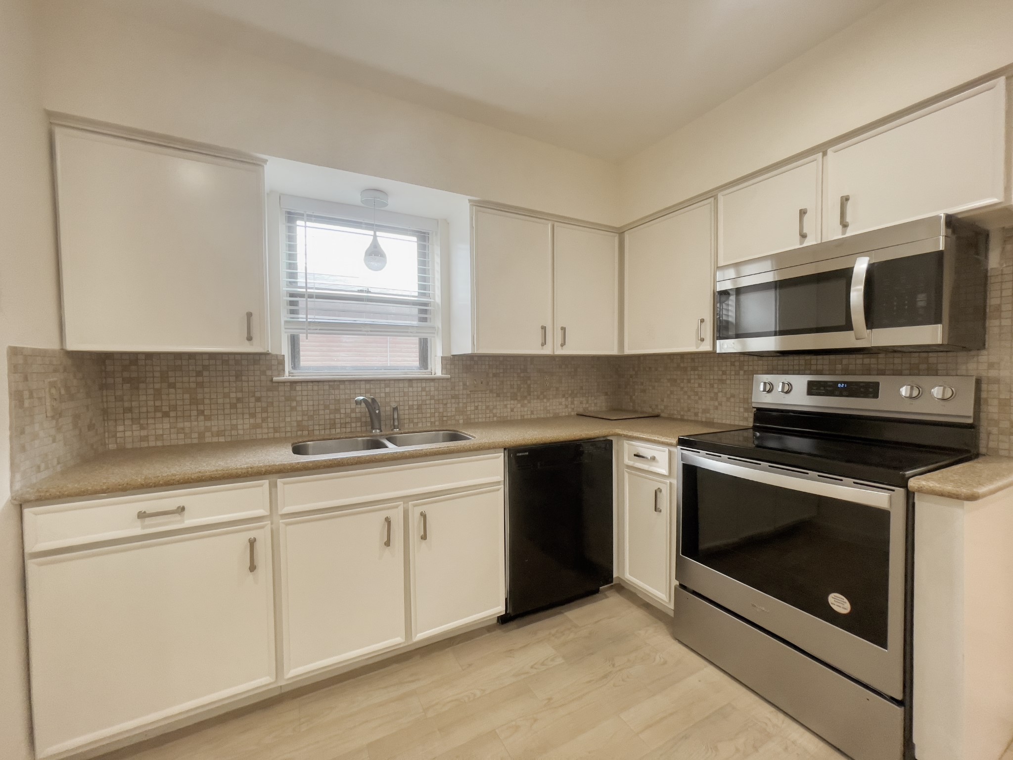 7710 Romney Road Houston, TX 77036 - Photo 4 of 31 a kitchen with granite countertop white cabinets stainless steel appliances and a sink