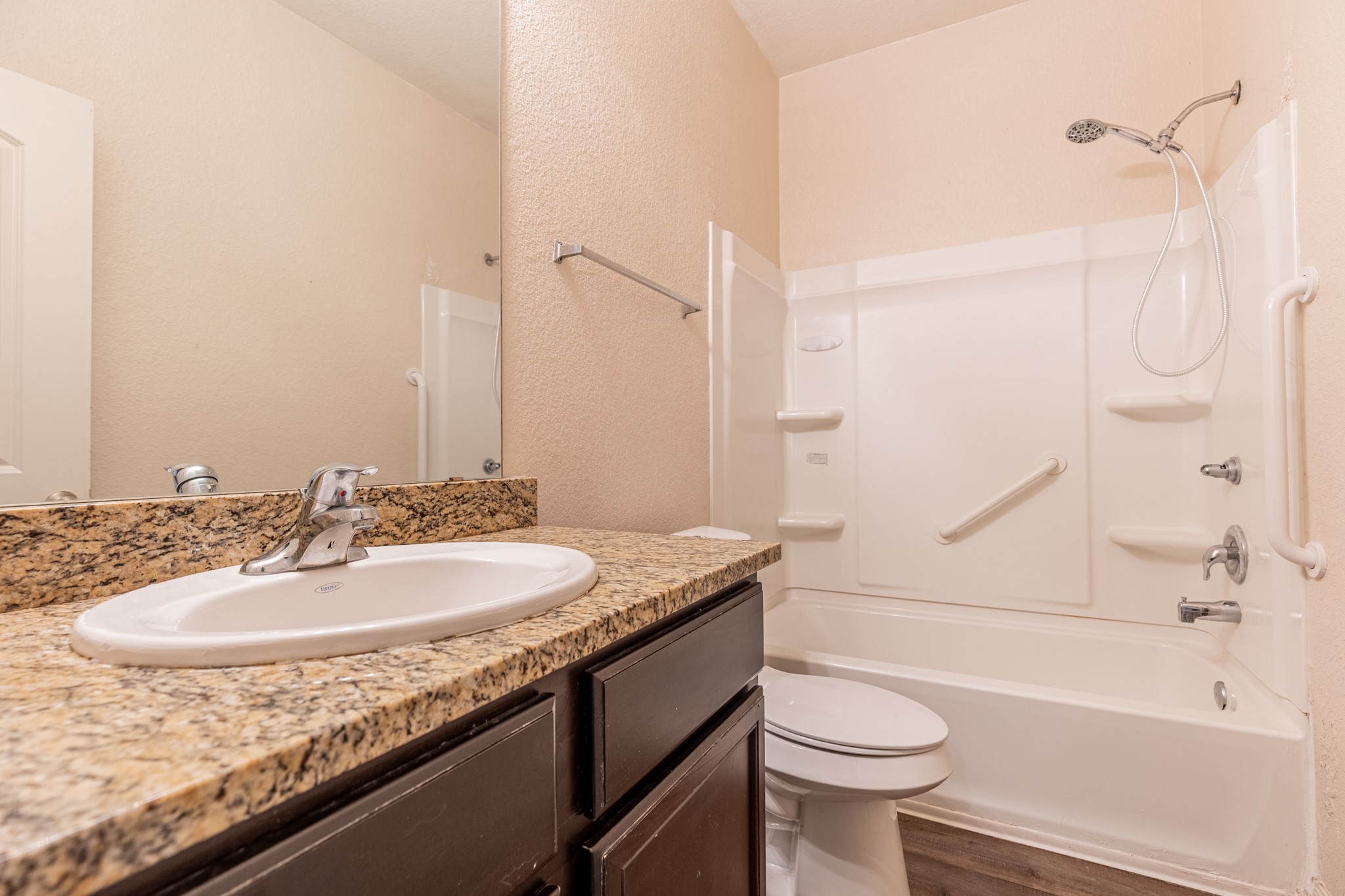 20017 Hubert R Humphrey Road Manor, TX 78653 - Photo 6 of 35 A well-appointed bathroom features a practical shower-tub combination and a vanity with granite counters.