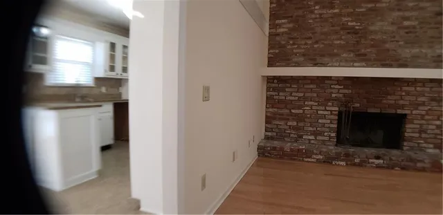 an empty room with windows and fireplace