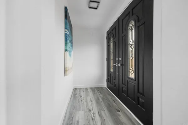 a view of a hallway with wooden floor