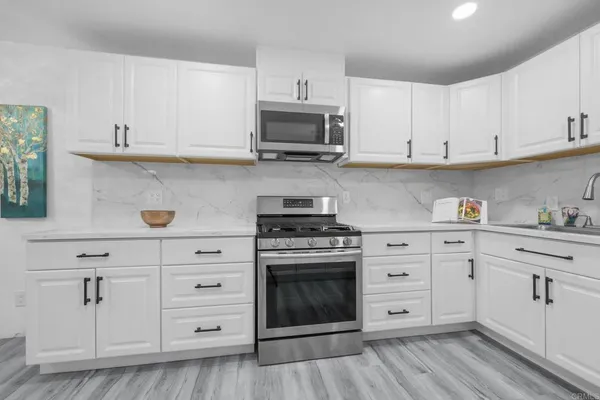 a kitchen with white cabinets and appliances