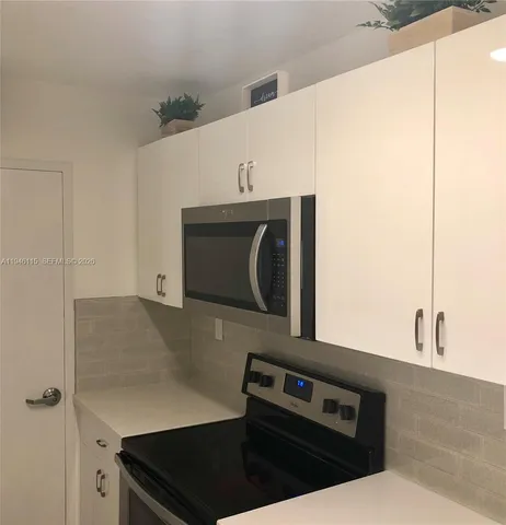 a kitchen with a refrigerator and cabinets